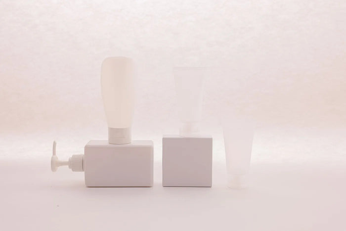 Unbranded blank-label skincare bottle in soft light, ingredient-label still life.