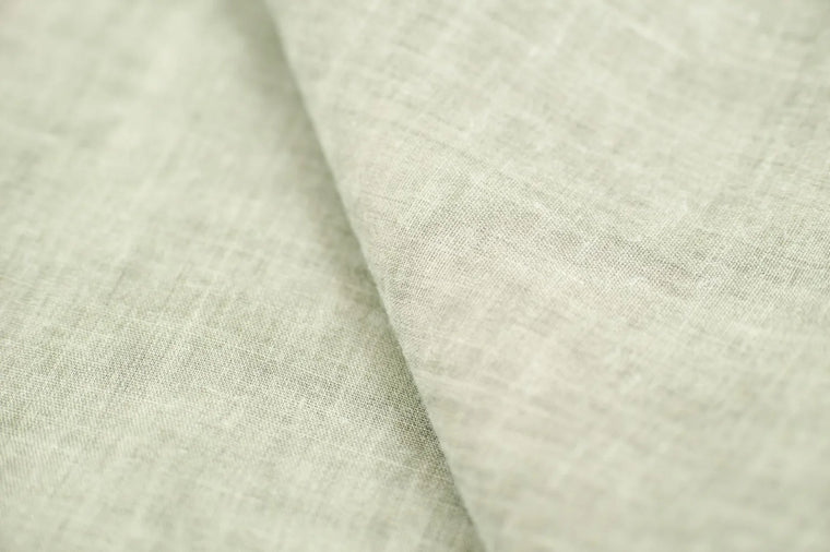 Soft linen and dried botanicals in calm light, gentle postpartum mood.