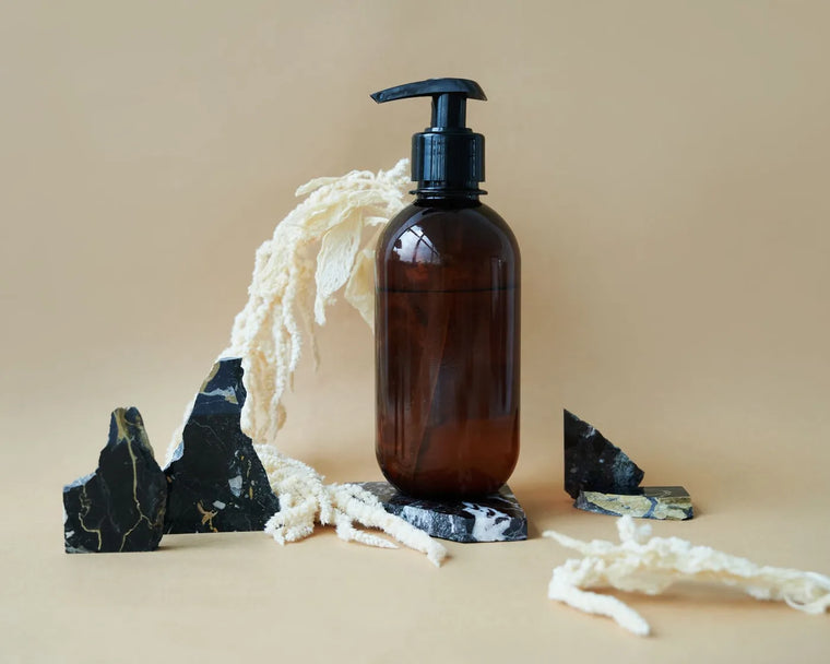 Minimal balm jar on slate in soft light, understated grooming still life.