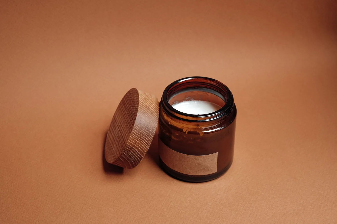 Balm jar on a wooden shelf in soft light, shelf-life storage still life.