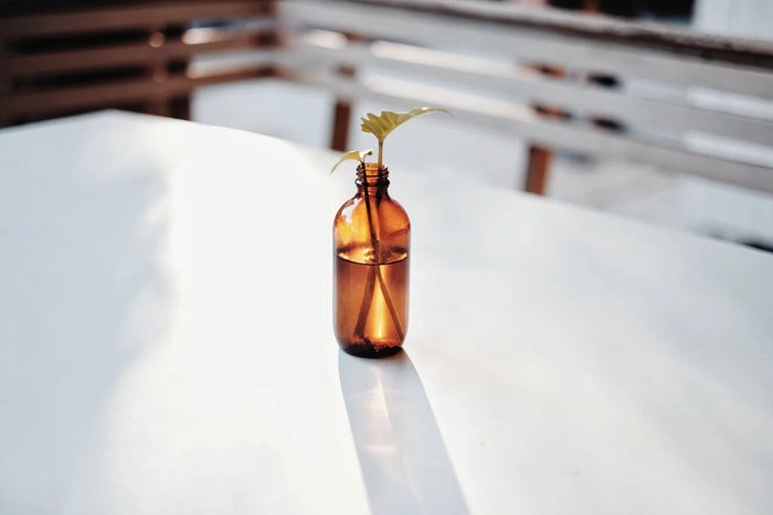 Golden facial-oil bottle in soft neutral light, sebum-mimicking oils comparison.