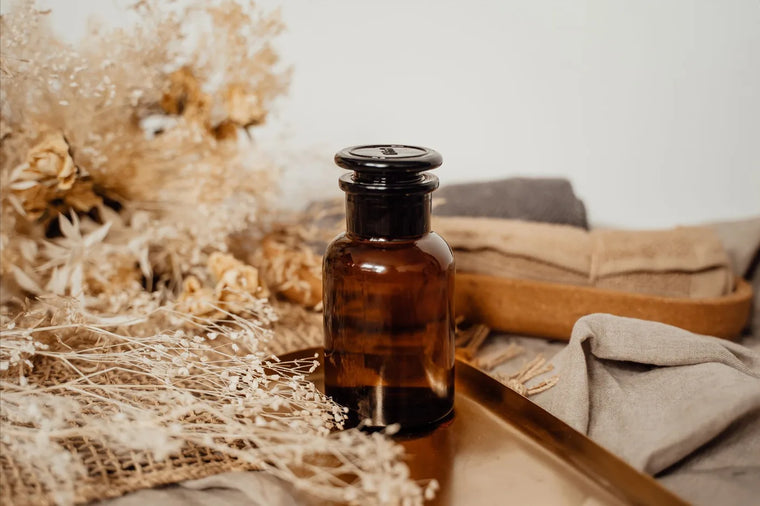 Antique amber apothecary bottle in warm light, historical skincare still life.
