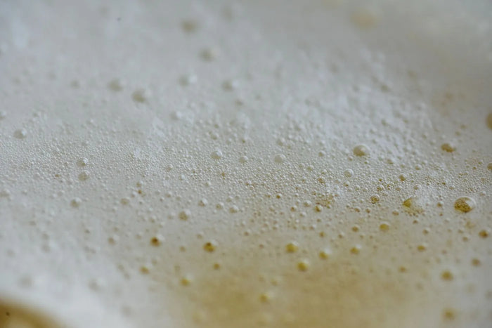 Smooth cream texture macro in soft beige light, pore-friendly skincare mood.