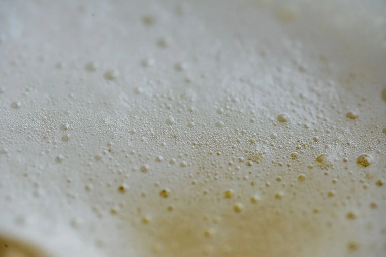 Smooth cream texture macro in soft beige light, pore-friendly skincare mood.
