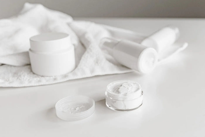 Plain white cosmetic jar with soft shadow, minimal fragrance-free skincare.