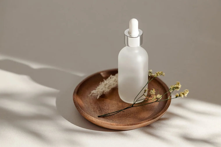 Frosted glass serum bottle in soft neutral light, water-free skincare formulation.