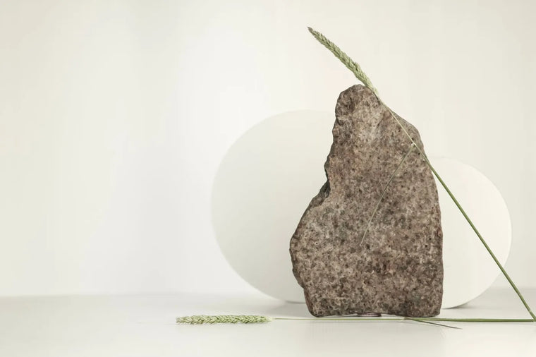 Smooth neutral stone texture in soft light, gentle skin-smoothing mood.