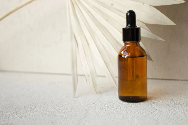 Amber glass dropper bottle in soft neutral light, minimalist skincare still life.