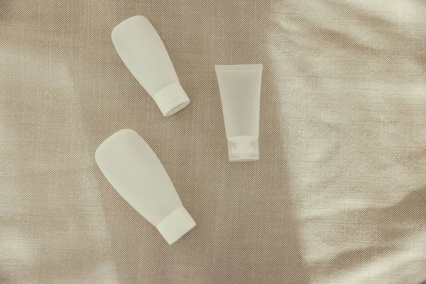 Minimal glass bottle with soft shadow in neutral light, skincare formulation still life.