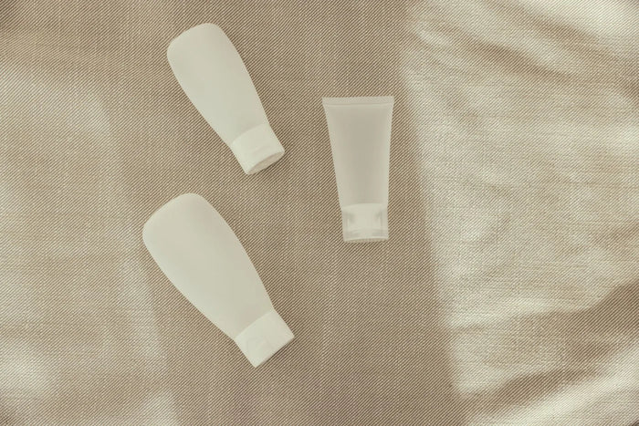 Minimal glass bottle with soft shadow in neutral light, skincare formulation still life.