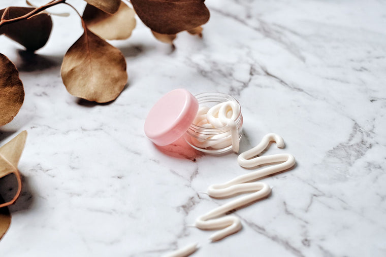 Two neutral skincare jars in soft daylight, product comparison still life.
