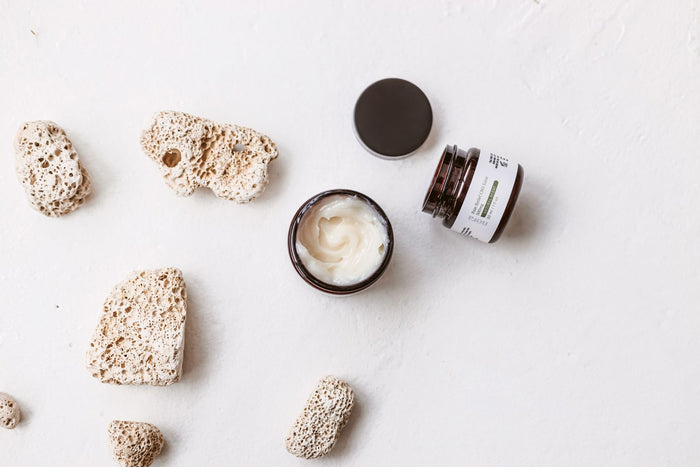 Neutral linen and balm still life in soft light, dry-skin care mood.
