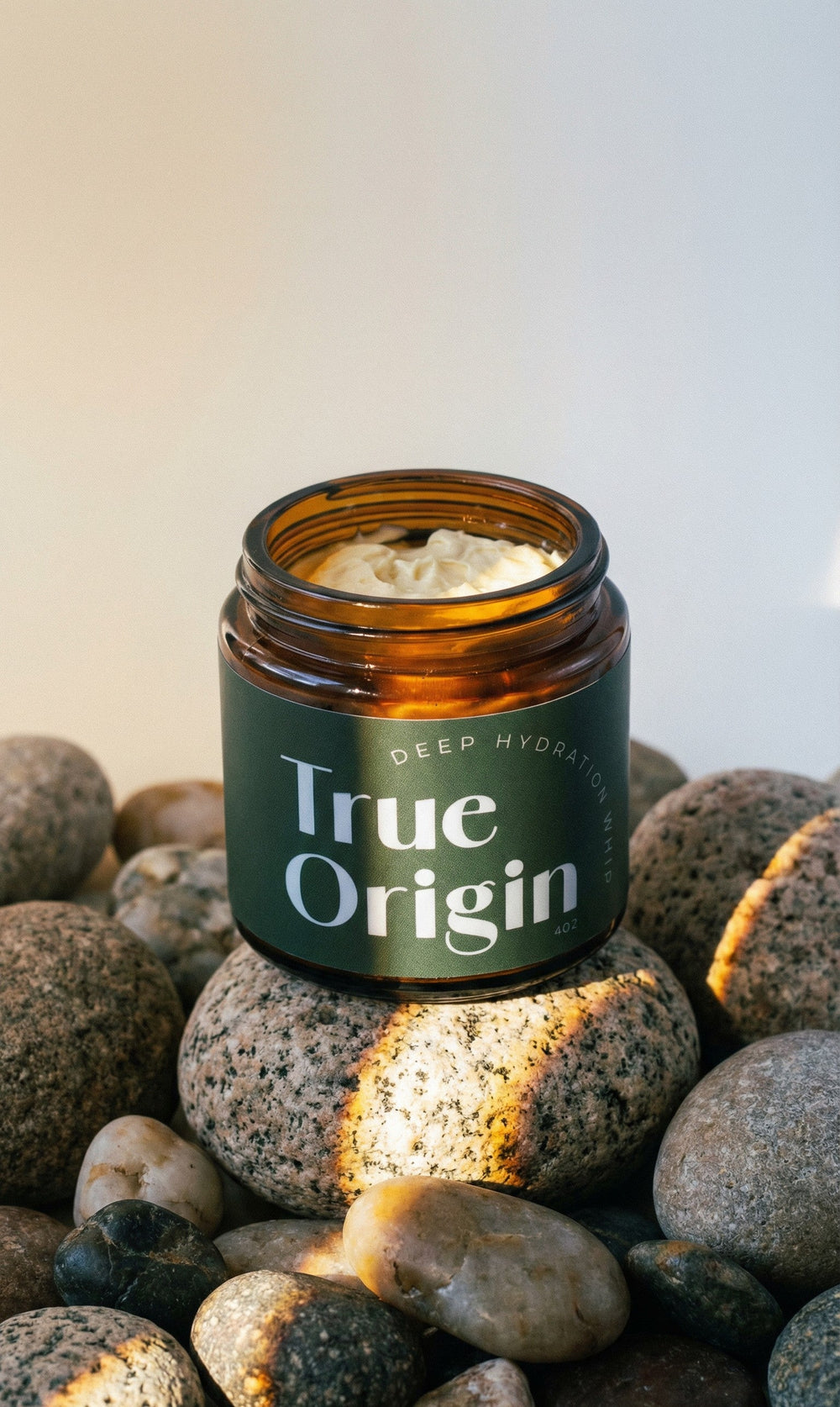 True Origin Deep Hydration Whip on river stones