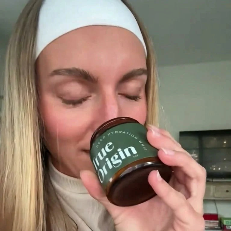 Woman smelling an open jar of Deep Hydration Whip tallow moisturizer