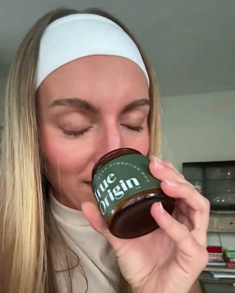 Woman smelling an open jar of Deep Hydration Whip tallow moisturizer
